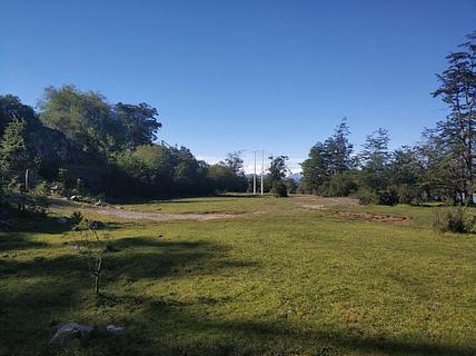 Grande área plana e gramada ao lado do rio