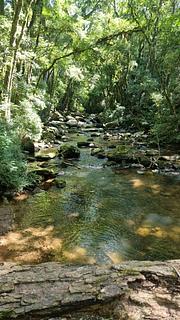 Ponto ao lado de estrada de terra e rio