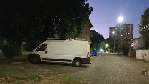 Praça com árvore e estacionamento